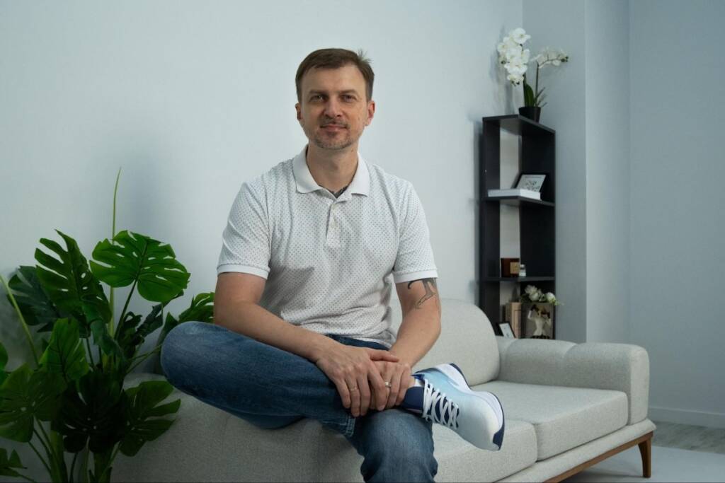 Vitalii Novitskii posing for professional photo in modern office setting; automotive service industry